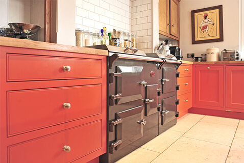 kitchen-extension-with-dark-grey-aga-cooker-and-red-kitchen-units